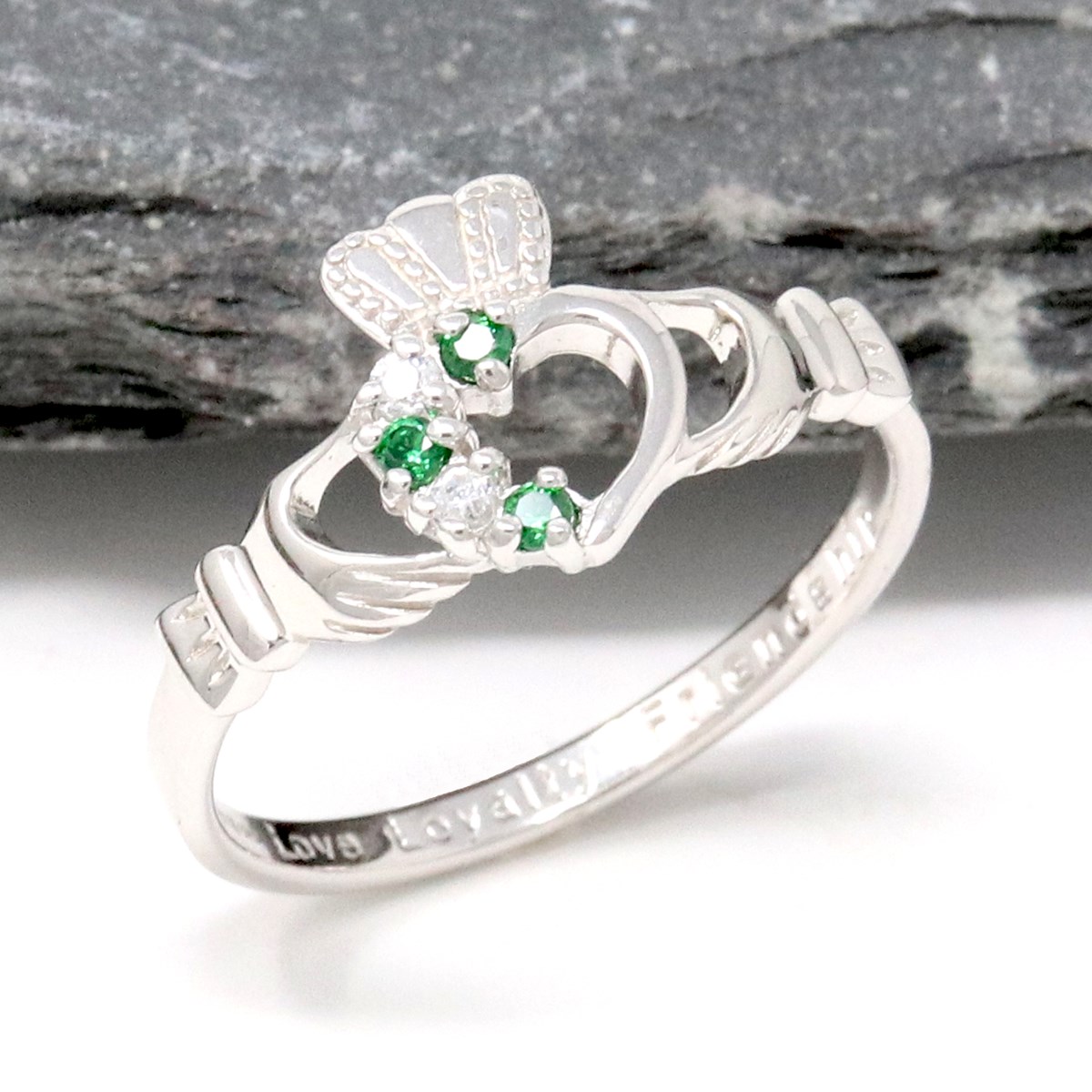 Claddagh ring with green emerald. Traditional Irish ring in shape of two hands  holding a heart shaped green gemstone. Symbol of love, loyalty and frie  Stock Photo - Alamy